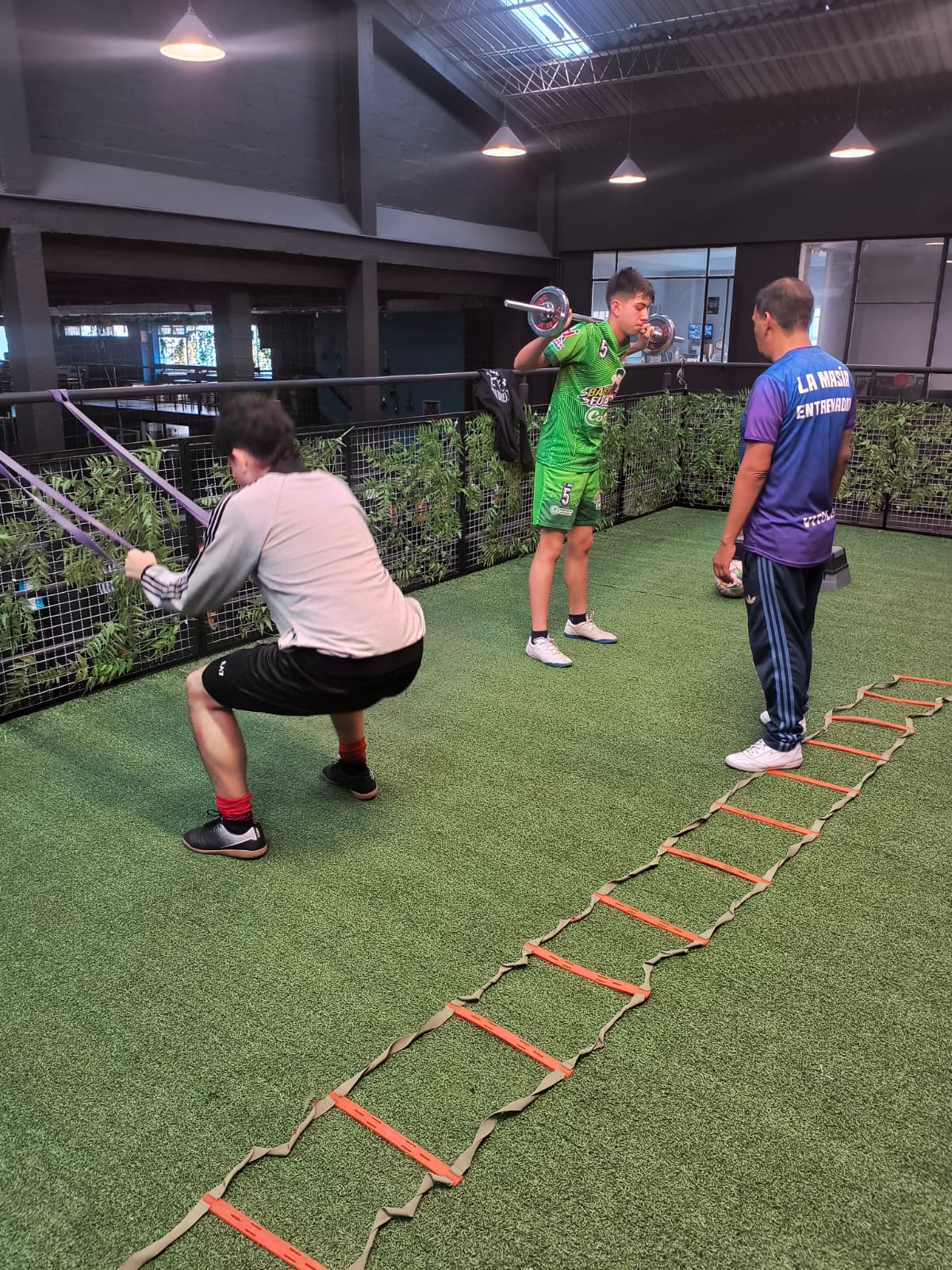 Acondicionamiento físico con barra olímpica para jugadores de fútbol